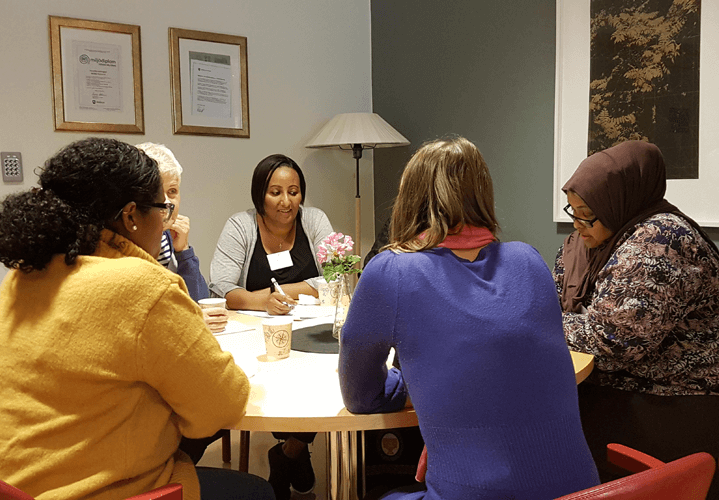 Grupp kvinnor vid bord under utbildning till palliativt ombud.